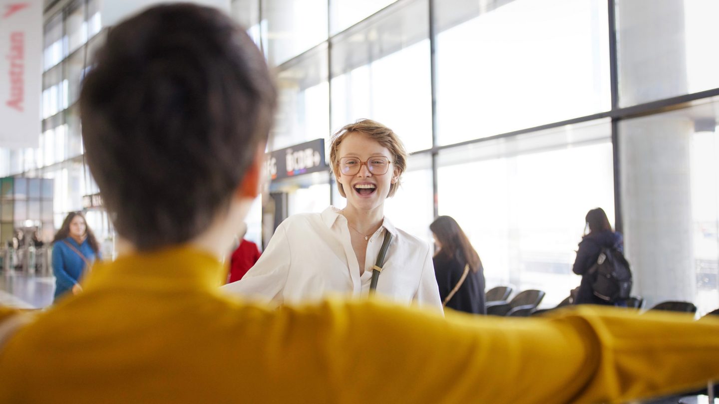 Deux femmes courant à la rencontre l’une de l’autre à l’aéroport.